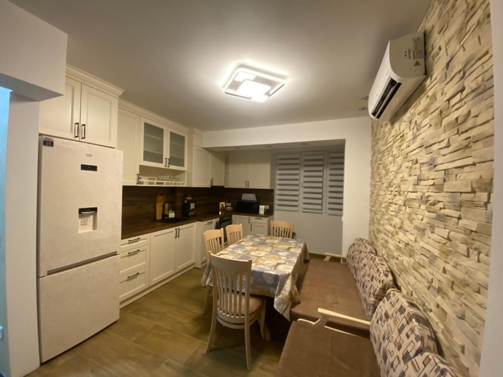 a kitchen with a table and a white refrigerator at Яни Хоум in Gabrovo