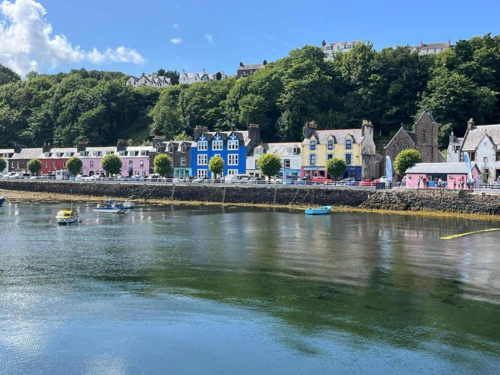 a town with colorful houses and a river at MacDonald Arms Hotel in Tobermory
