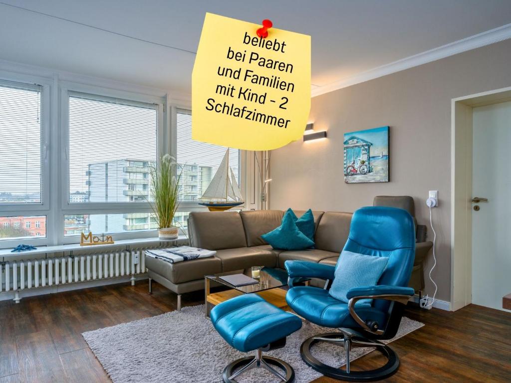 a living room with blue chairs and a couch at Skriien Mö TOP-Fewo 4 Sterne 5 Min zum Strand Balkon 2 SZ TG Zentrum in Westerland
