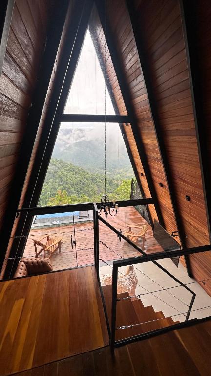 a room with a large window and a swing at Black Hut in Domingos Martins