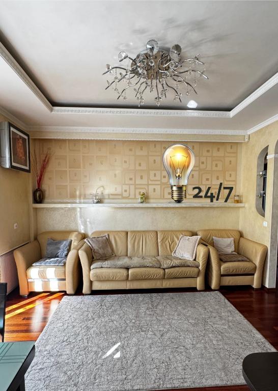 a living room with a couch and a light bulb on the wall at Квартира на Шевченка in Kamianets-Podilskyi