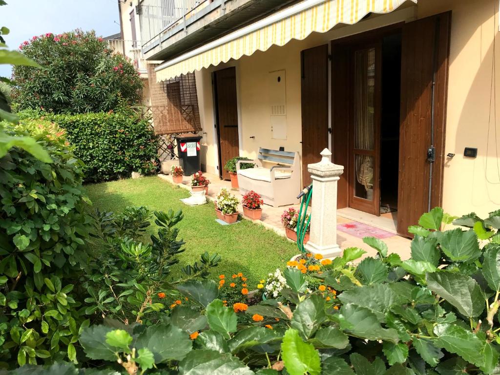 a garden with plants and flowers in front of a house at Casa Aurora Gardalake in Cavalcaselle