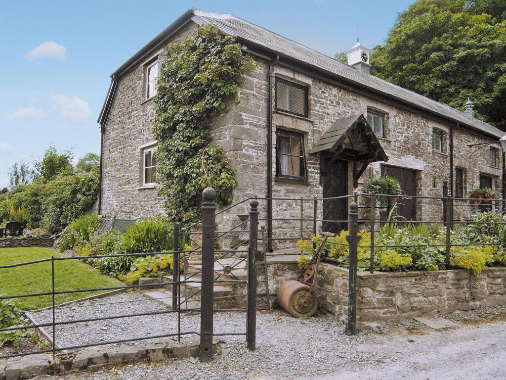 an old stone house with a gate in front of it at Gamekeepers Cottage - Hw7729 in Llangadog