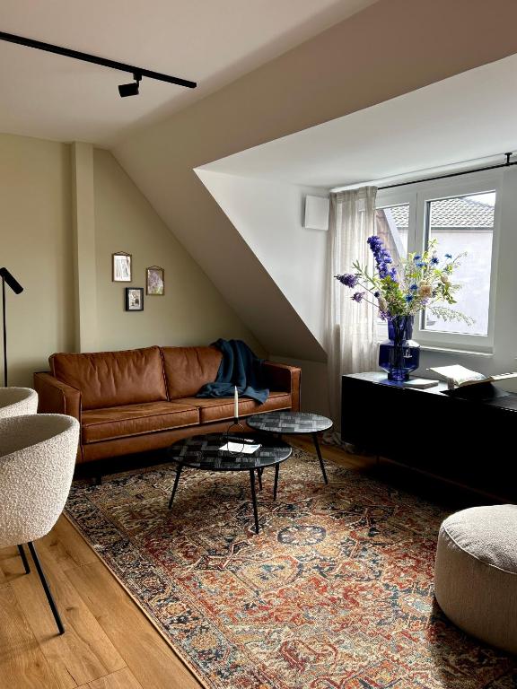 a living room with a brown leather couch and a table at Emils City Suite in Vreden