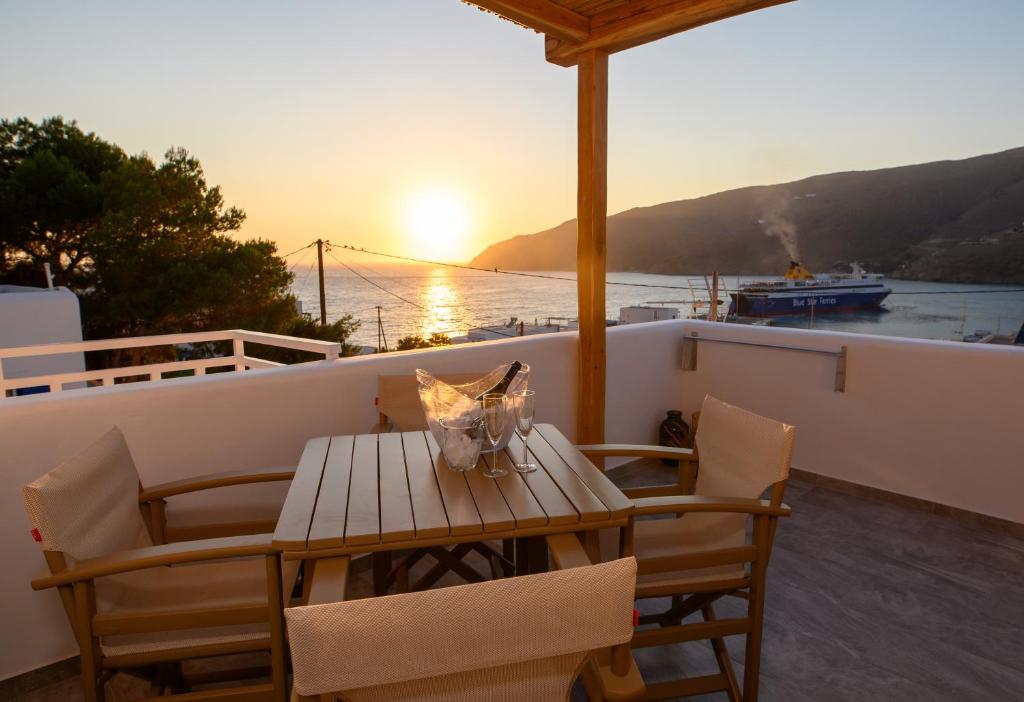 a table and chairs on a balcony with the sunset at Le Reve in Aegiali