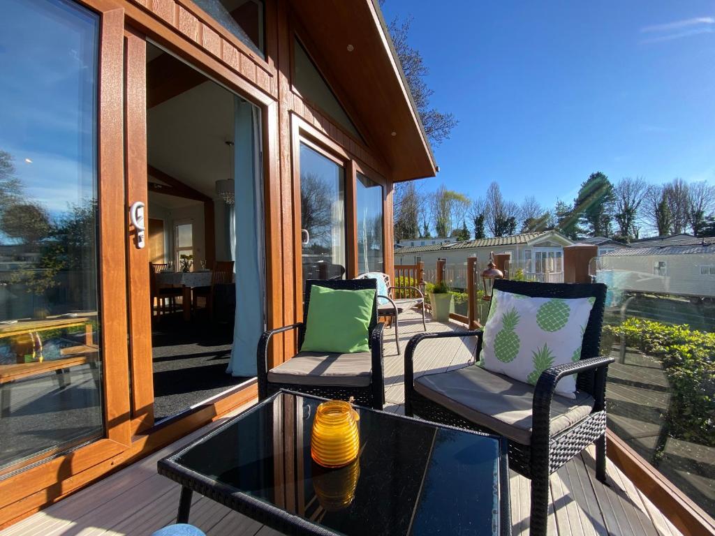 a porch with two chairs and a glass table at Sunset Lodge in Poole