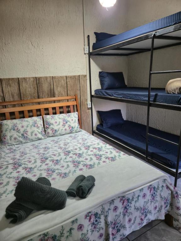 a bedroom with two bunk beds with shoes on the bed at Pousada Casa da arara Suite 106 in Saquarema