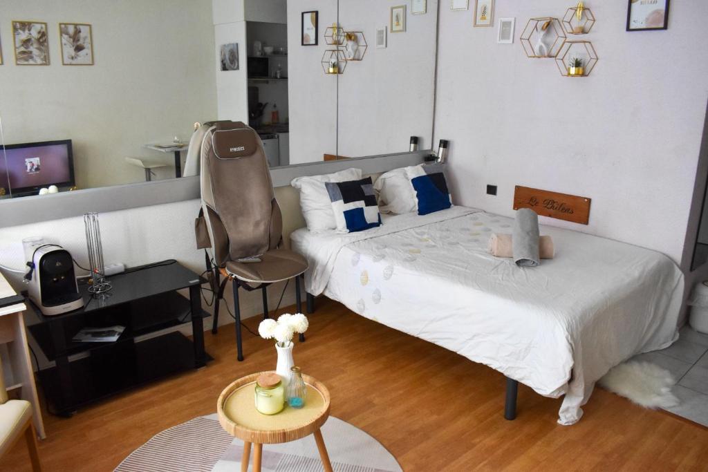 a bedroom with a bed and a desk and a chair at Nid Dor avec Parking in Carquefou
