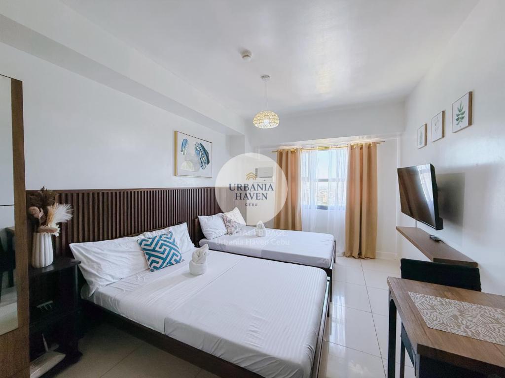 a hotel room with two beds and a television at Urbania Haven Cebu2 in Cebu City