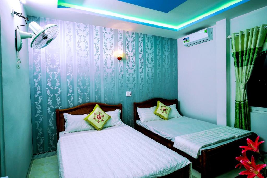 two beds in a room with blue walls at Phuc Hau Hotel - Ly Son in Ly Son