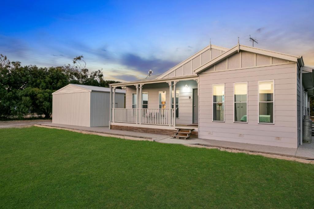 a white house with a lawn in front of it at CandE on Samphire in Kingscote