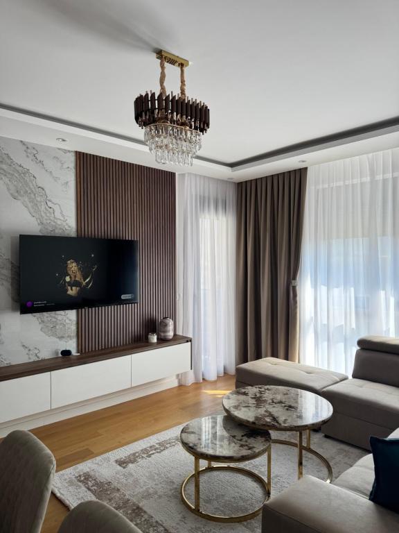 a living room with a couch and a table at Moderan 80m2 apartman - 2 kupatila - terasa - blizu centra i plaze in Bar