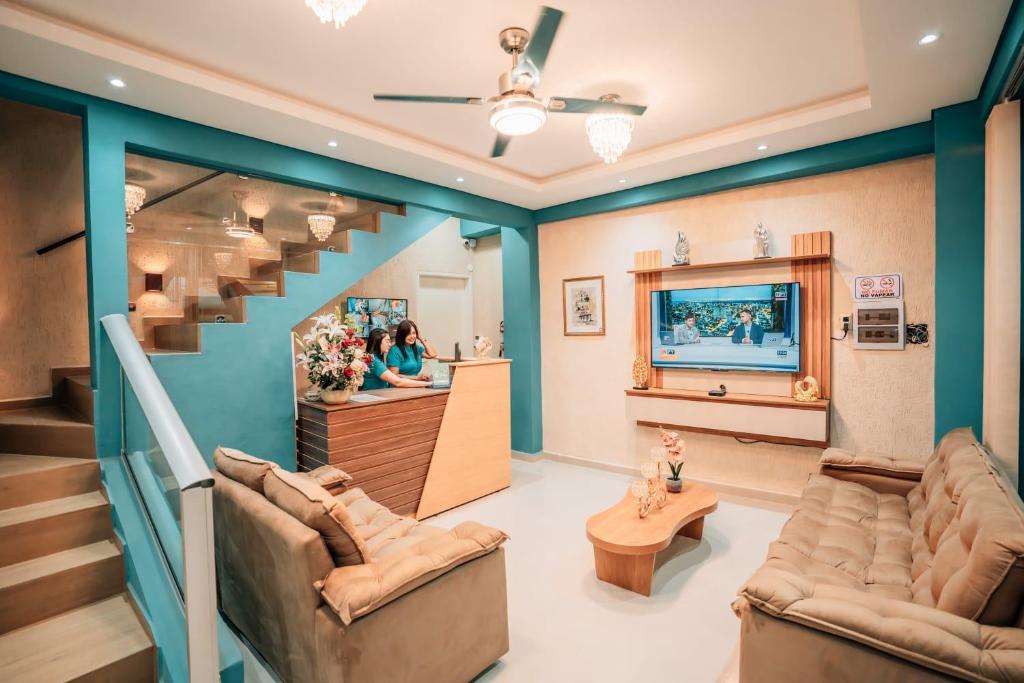a living room with two couches and a staircase at Hotel Urban Biz in Pilar