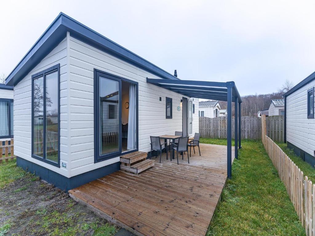 a small white house with a wooden deck at Bright Beachside Base in Burgh-Haamstede in Burgh Haamstede