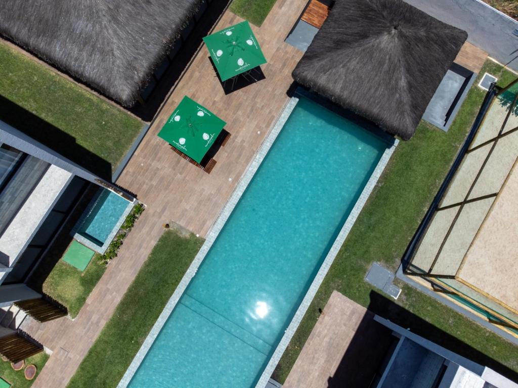 an overhead view of a swimming pool with an umbrella at Brisa e Sal in São Miguel dos Milagres