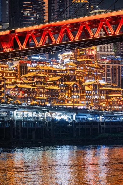 a view of a city at night from the water at Suli Hotel Chongqing,1 Min Walk to Metro,Near Jiefangbei&Hongya Cave,International guest-friendly,Free Self-Service Laundry,Free High-Speed WiFi,Free Chinese Tea,Free Travel Advice in Chongqing