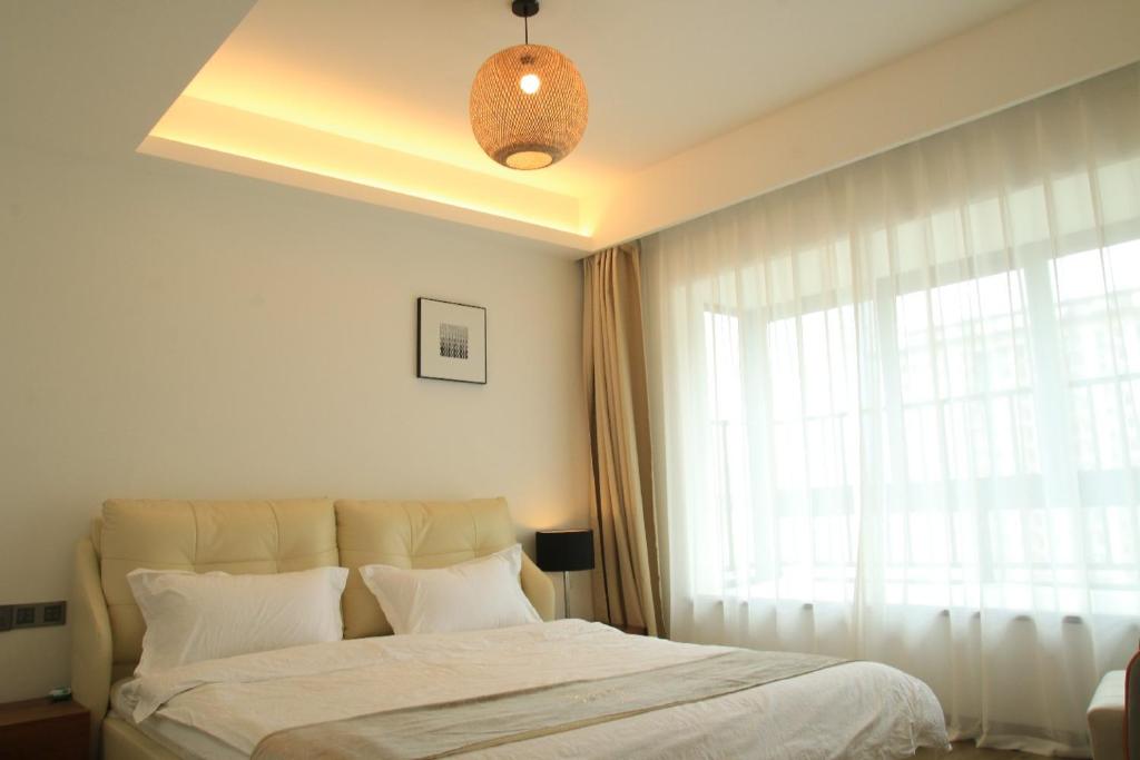 a bedroom with a large bed and a window at Miri apartment in Kunming