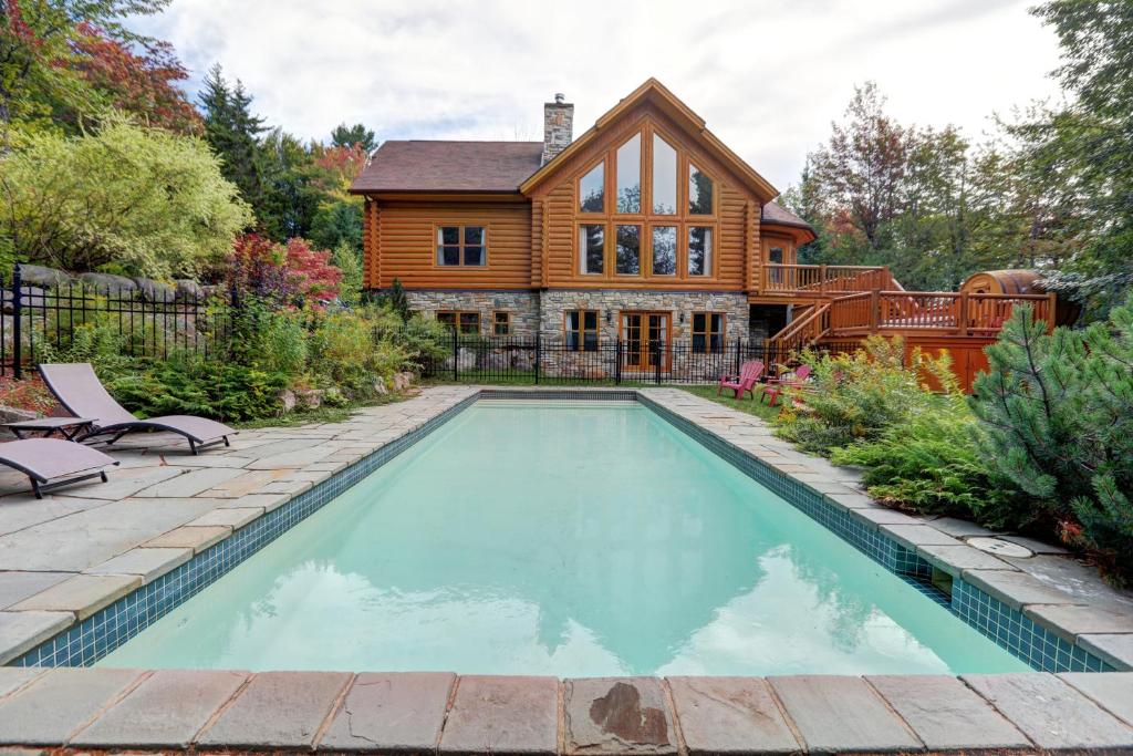 a house with a swimming pool in front of a house at Fiddler Lake Resort - Deer 80 in Mille-Isles