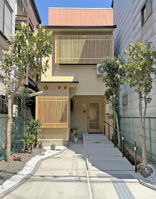 a building with a gate and a sidewalk with trees at 東寺の宿夏 in Kyoto
