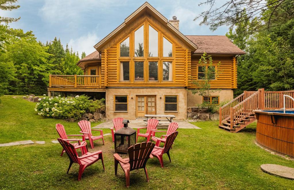 a log home with a table and chairs in the yard at Fiddler Lake Resort - Deer 41 in Mille-Isles