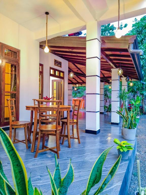an outdoor patio with wooden tables and chairs at NRS Villa Midigama in Midigama East