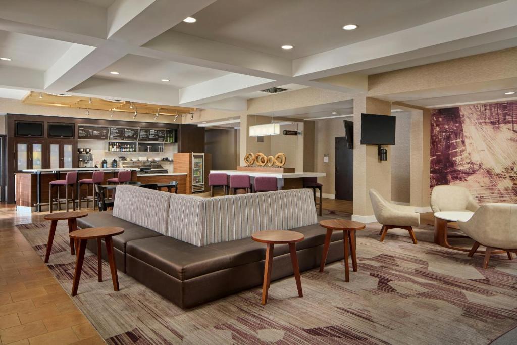 a lobby with a couch and chairs and a bar at Courtyard Newark Granville in Newark