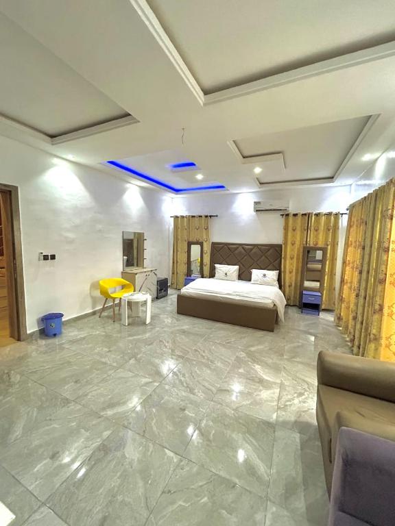 a large room with a bed and a yellow table at City Xcape Niche in Lekki