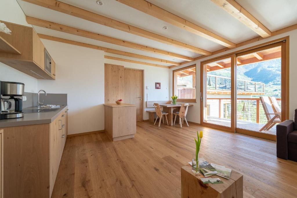 a kitchen and living room with a table and chairs at Moosbichlerhof in Marlengo