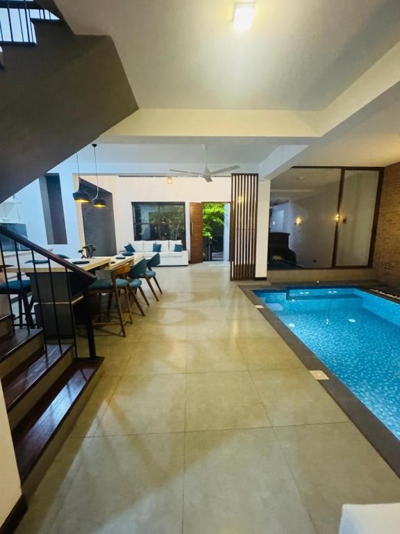 a house with a swimming pool and a dining room at Mack Win Villa in Pannipitiya