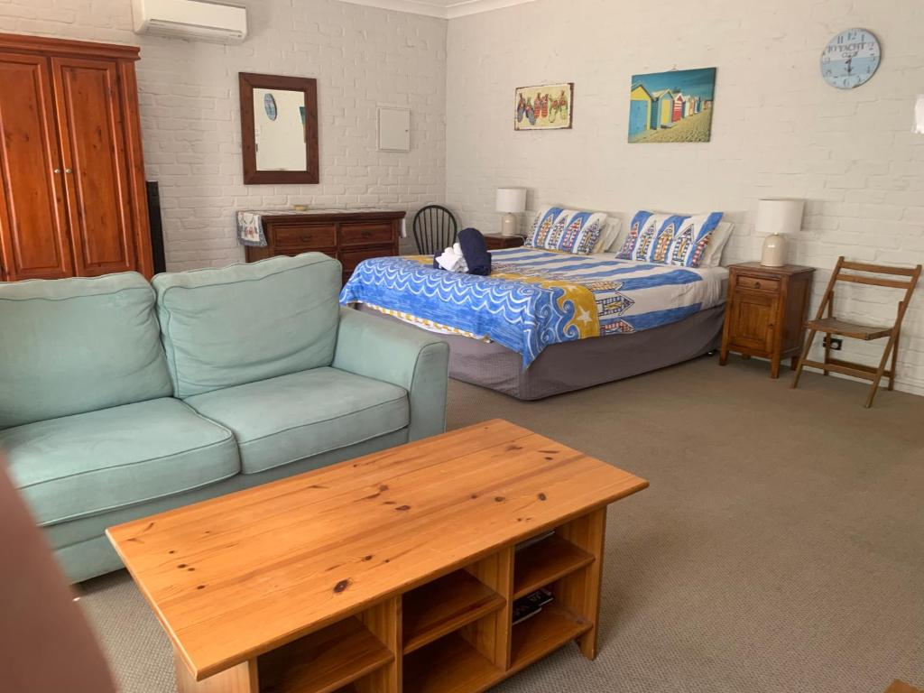 a living room with a bed and a couch at Bentworth Lodge in Carramar