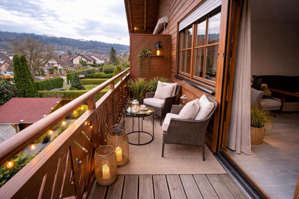 a porch with chairs and a table on a balcony at Luxury Rhine Retreat Garten&Sauna in Busingen am Hochrhein
