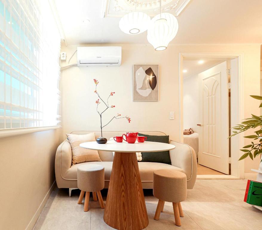 a living room with a table and a chair at Hongdae#Hongik Univ Station 9 min Walk#Airport Railroad Access#Free Parking#Free Netflix#Free WiFi#Luggage Storage#Washer and Dryer in Seoul