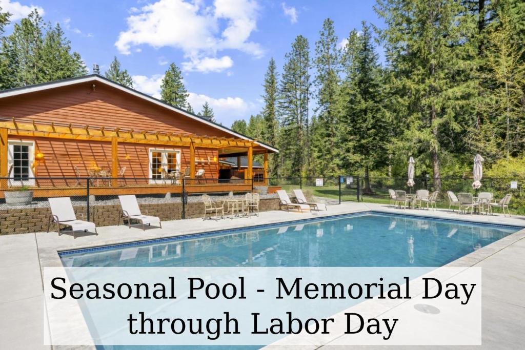 a log cabin with a pool in front of it at River Road Lodge by NW Comfy Cabins in Leavenworth