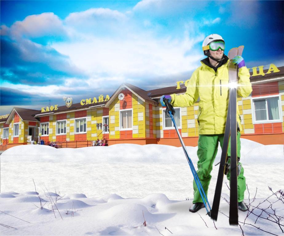 un hombre está parado en la nieve con esquís en Hotel Smile, en Abzakovo