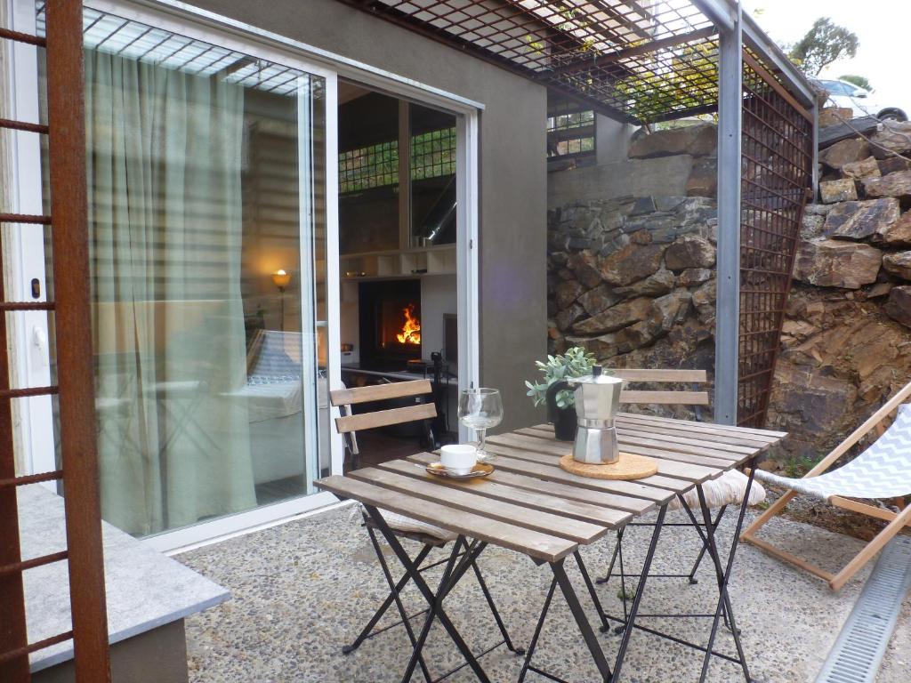 a wooden table on a patio with a fireplace at Apartment Rovellada Platja in Colera