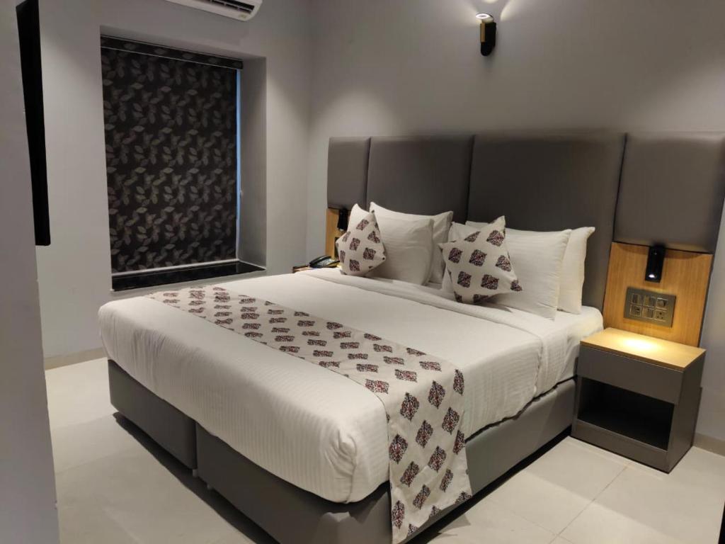 a bedroom with a large bed and a window at Ramanashree California Resort in Yelahanka