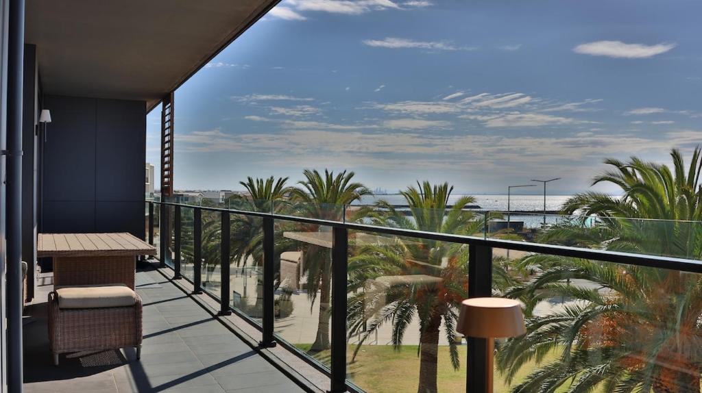 a balcony with palm trees and a view of the ocean at Beach paradise in Werribee South