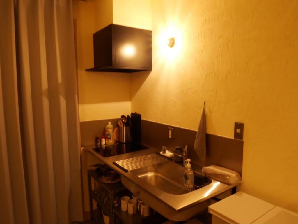a bathroom with a sink and a toilet at HITOYANE guesthouse-1日1組限定- in Aizuwakamatsu
