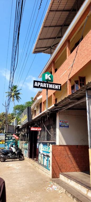 a building with a sign on the side of a street at K Apartment in Varkala
