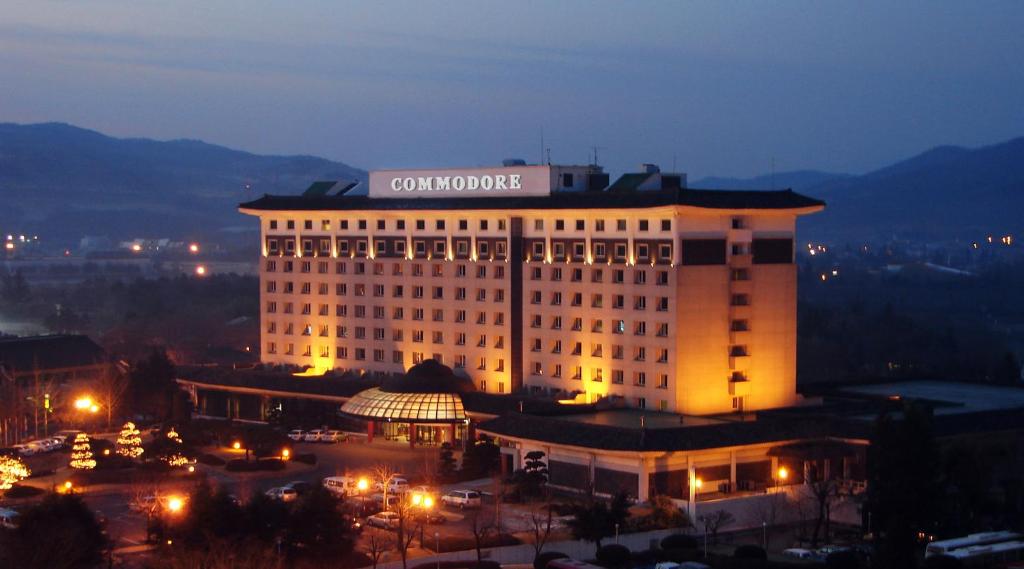 Commodore Hotel Gyeongju في جيونجو: مبنى عليه علامة في الليل