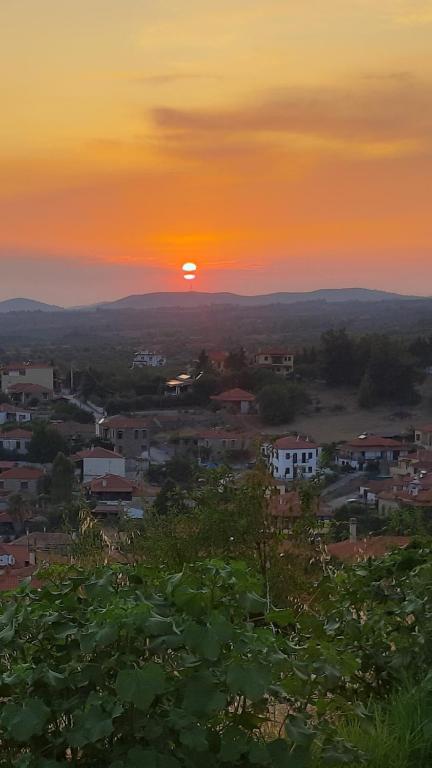 a sunset over a town with the sun in the sky at Hill View in Nikiti