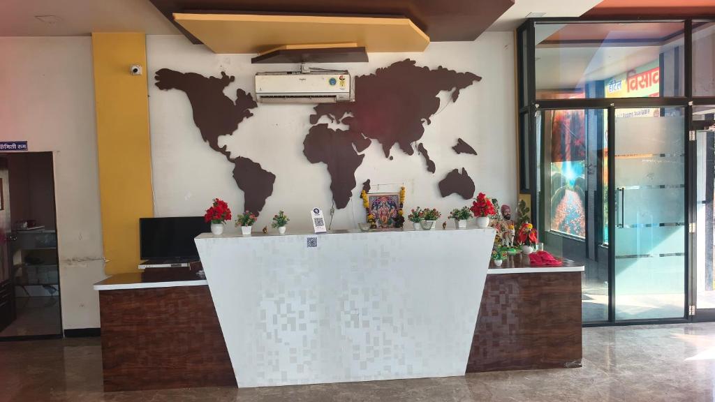a lobby with a world map on the wall at Hotel Visava Restaurant & Lodging in Vaghunde Budrukh