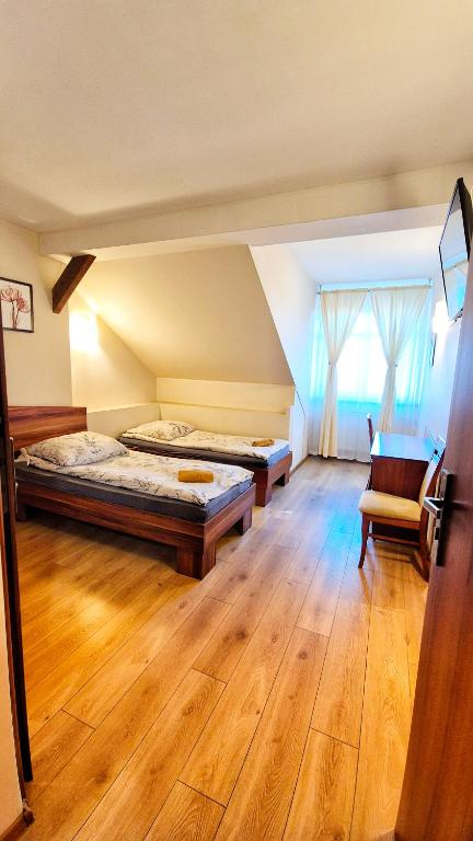 a room with two beds and a chair in it at Noclegi Tyczyn in Tyczyn