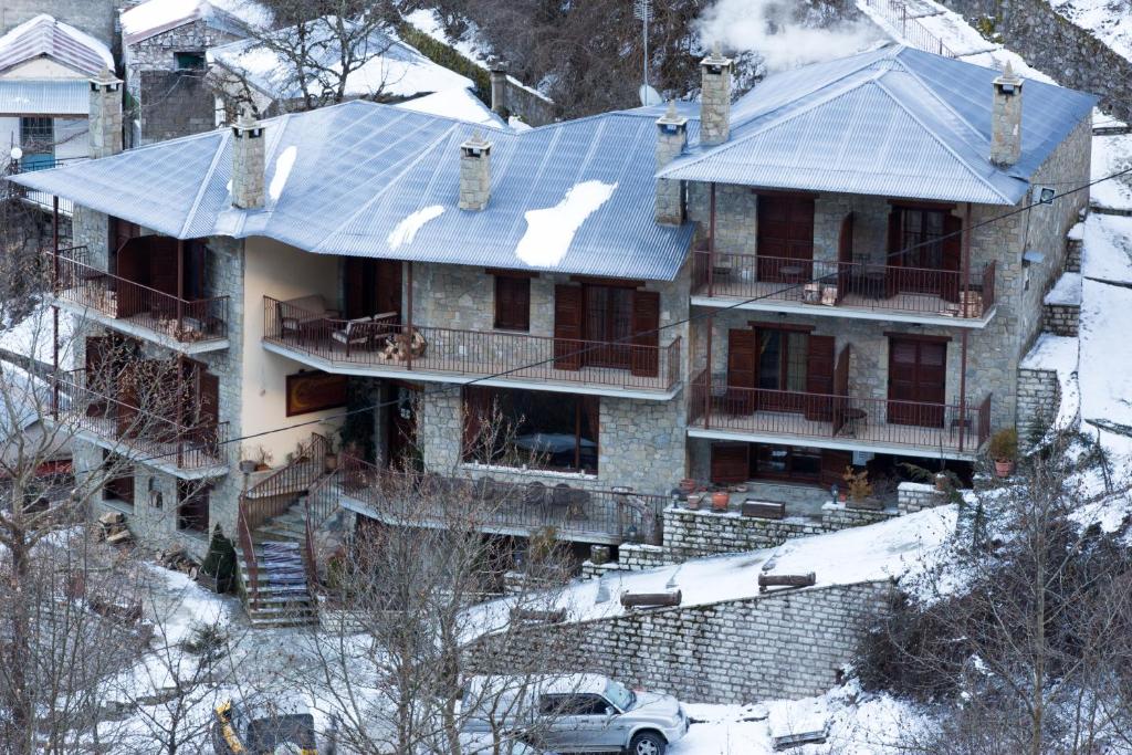 an aerial view of a house with snow on the ground at Archontiko Velousi in Pantévgeni