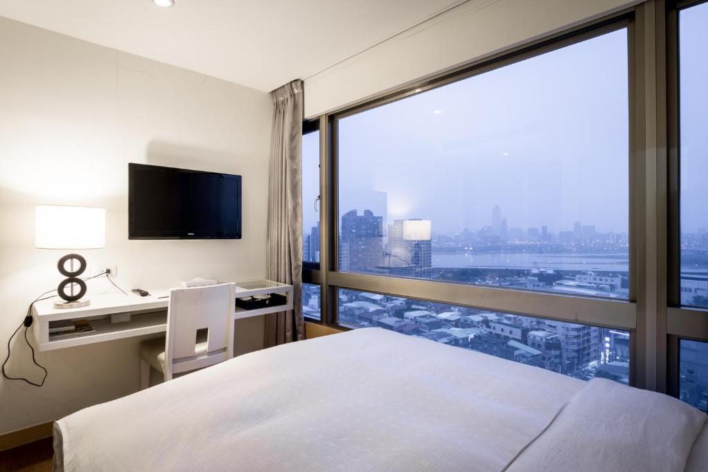 a hotel room with a bed and a large window at Wemeet Hotel Taipei in Taipei