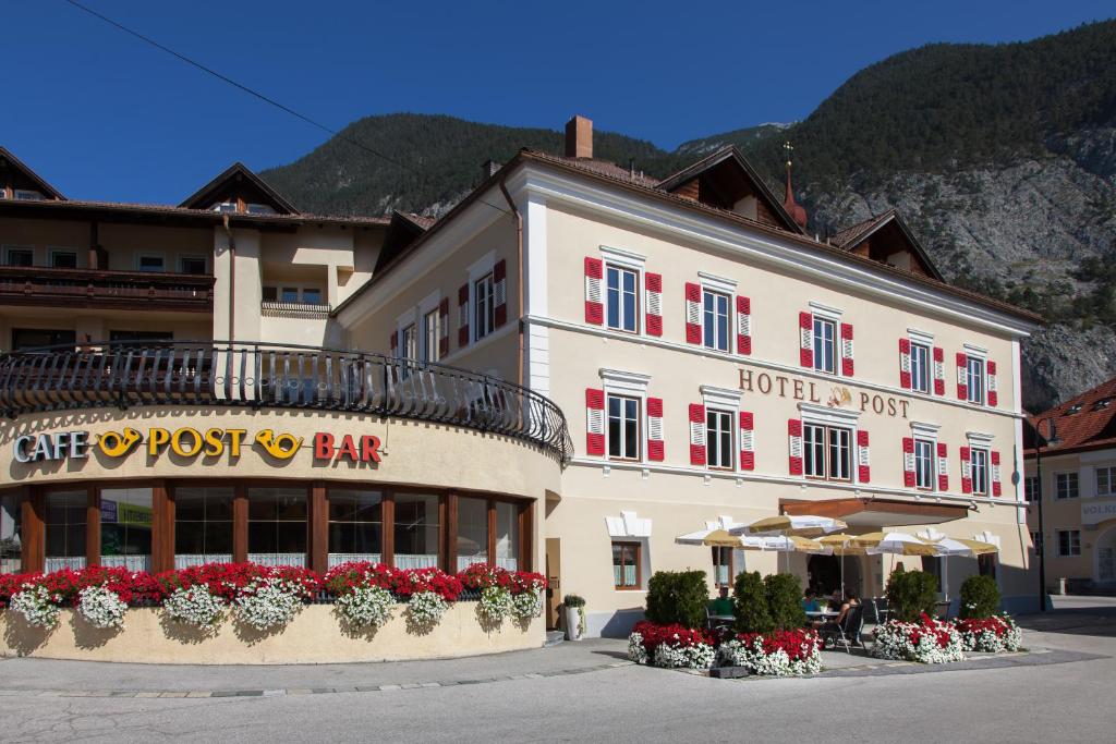 ein Gebäude mit einem Hotel mit Blumen davor in der Unterkunft Sterzinger Posthotel in Nassereith