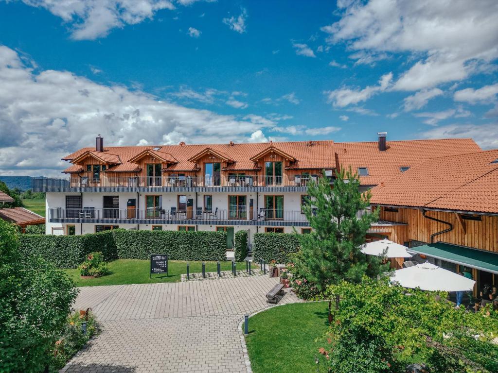 ein großes Gebäude mit rotem Dach in der Unterkunft Danner-Hof in Kochel