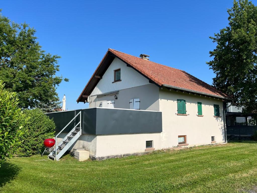 a large white house with a red roof at Gite Les Hirondelles in Langatte