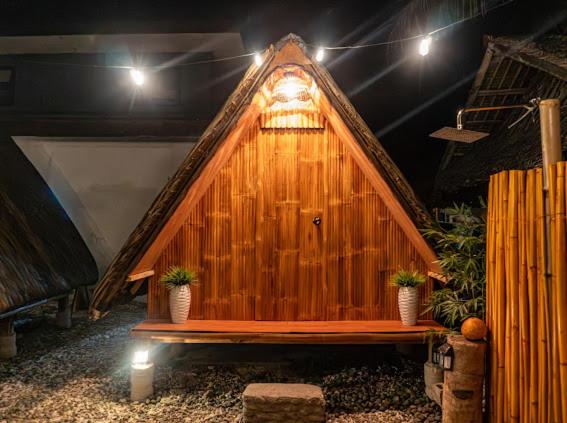 a large wooden house with a bench in front of it at CocoHaus in Batangas City