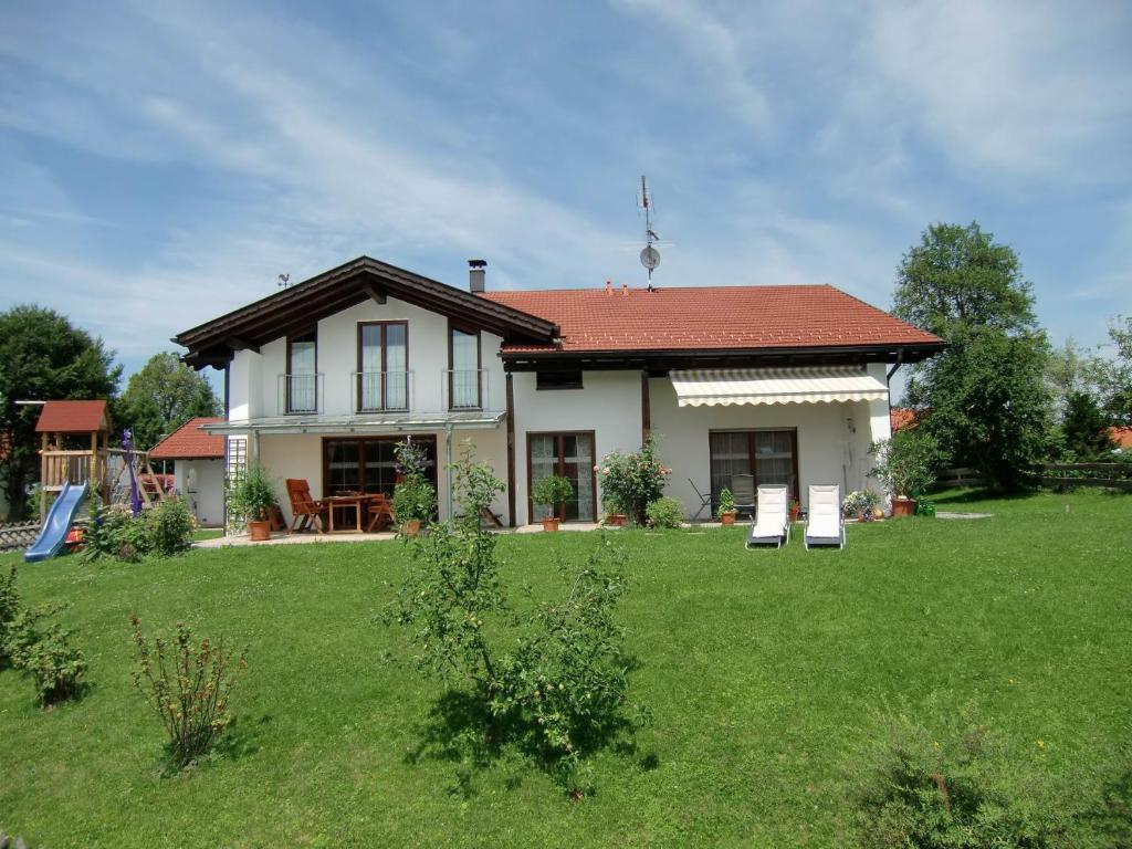 a house with a green lawn in front of it at Fewo Bergruah in Bad Bayersoien